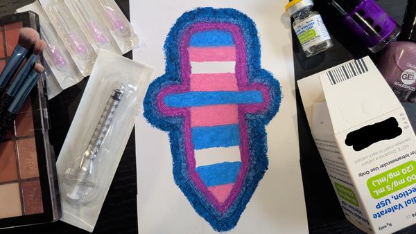 Picture of a drawing of a knife made of trans flag colors, surrounded by estradiol injection supplies, makeup, and nail polish.